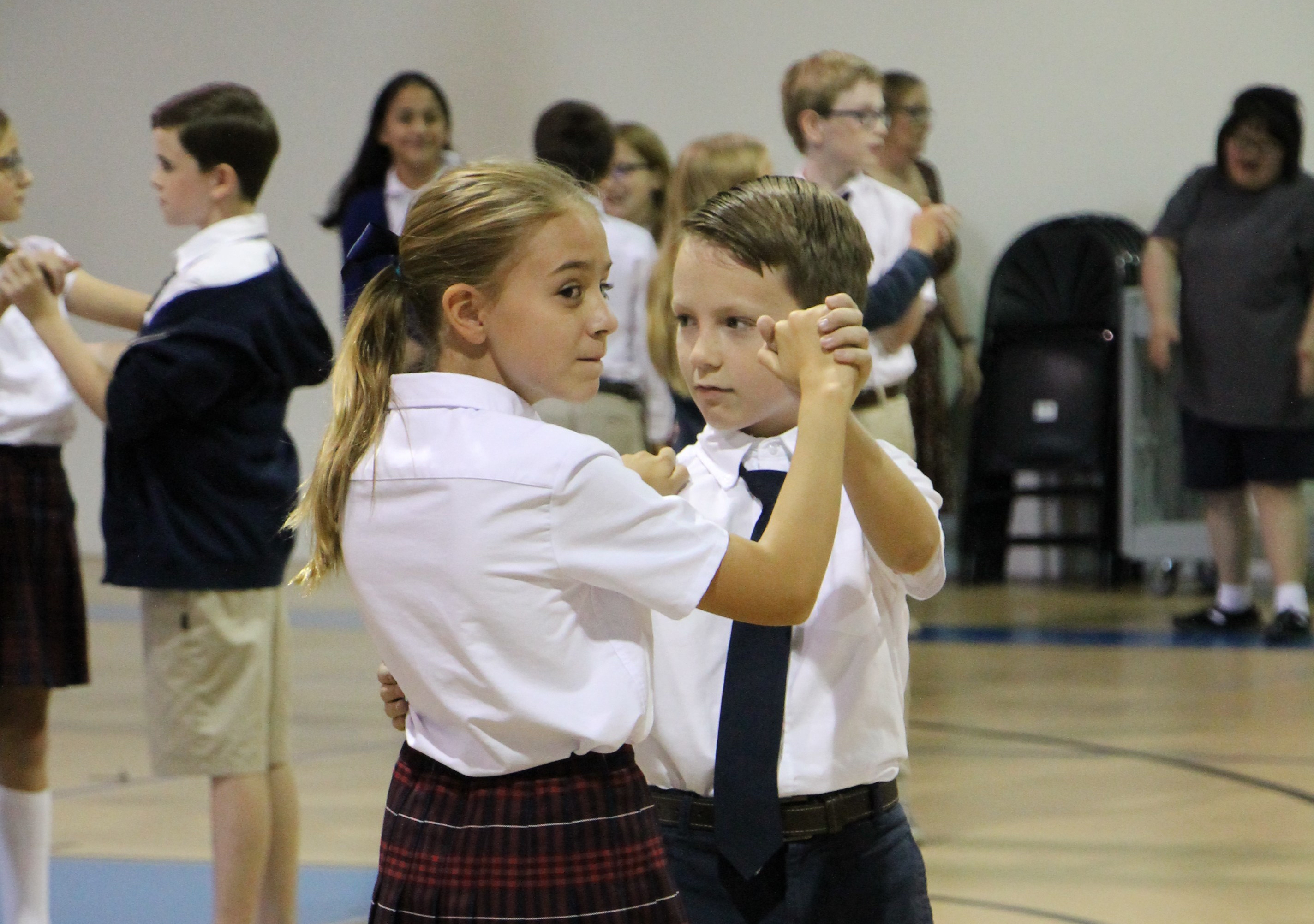 Girl and boy in school uniforms dancing
